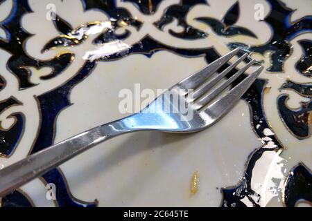 Svuotare la piastra dopo il pasto con una forchetta Foto Stock