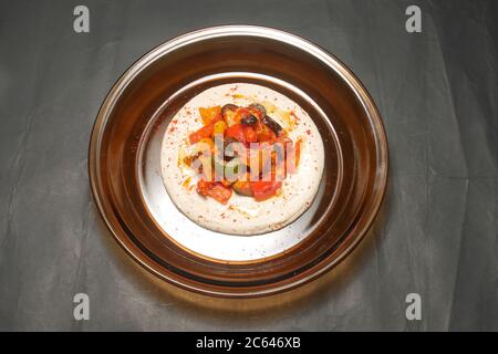 HARISSA MESCOLARE LE VERDURE FRY SU UN LETTO DI HUMMUS Foto Stock