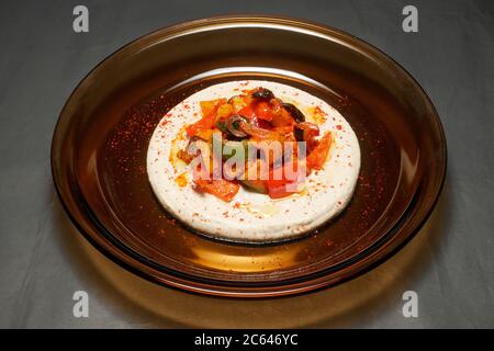 HARISSA MESCOLARE LE VERDURE FRY SU UN LETTO DI HUMMUS Foto Stock