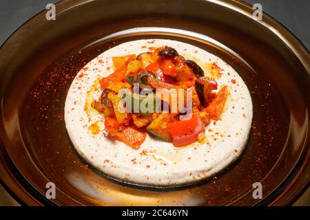 HARISSA MESCOLARE LE VERDURE FRY SU UN LETTO DI HUMMUS Foto Stock