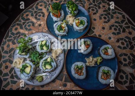 Panini di sushi vegano fatti in casa con riso, alghe, tofu, avocado e altri sapori. Foto Stock