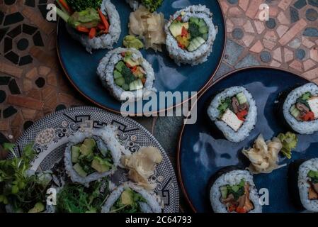 Panini di sushi vegano fatti in casa con riso, alghe, tofu, avocado e altri sapori. Foto Stock