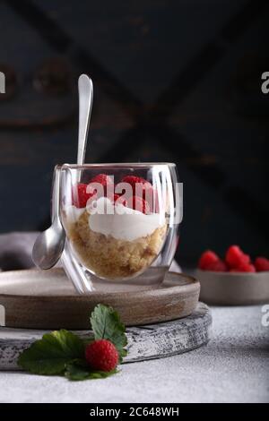 Dessert trifle con lamponi freschi in un bicchiere Foto Stock