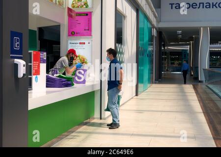 Ristorante di corte di cibo ai centri commerciali durante la quarantena Coronavirus COVID-19 . Consegna del cibo da portare via. Orientamento sociale che si allende persone che si tengono dentro Foto Stock