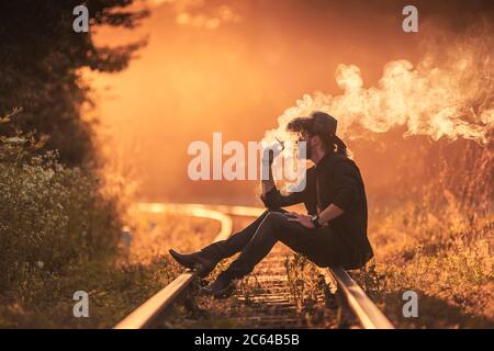 cowboy che fuma una sigaretta sulla linea ferroviaria Foto Stock