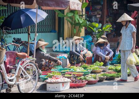 Signore vietnamite che vendono frutta e verdura in un tradizionale mercato di strada vietnamita a Hoi An Vietnam Foto Stock