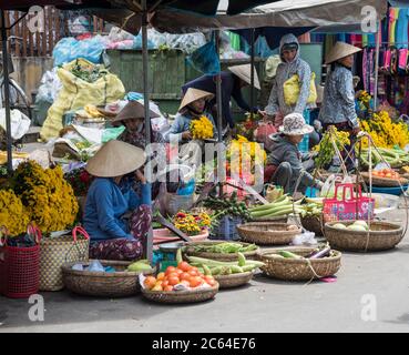 Signore vietnamite che vendono frutta e verdura in un tradizionale mercato di strada vietnamita a Hoi An Vietnam Foto Stock