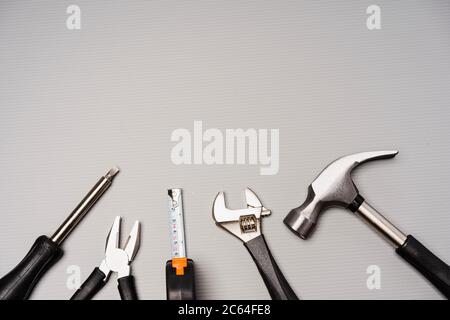 Composizione piatta di un set di utensili, tra cui martello, pinze, chiave, cacciaviti e nastro di misurazione. Vista dall'alto, concetto per il giorno del padre, inclusi Foto Stock