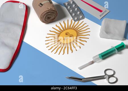 Bandiera Argentina con kit medico di primo soccorso su sfondo tavolo di legno. Concetto nazionale del sistema sanitario, tema medico. Foto Stock