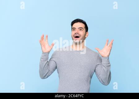 Sorpreso uomo caucasico che gasting e alzando le mani su isolato su sfondo azzurro Foto Stock