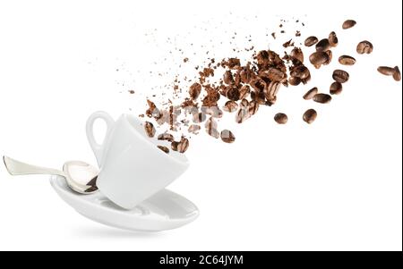 i chicchi di caffè e la polvere fuoriescono da una tazza isolata in bianco Foto Stock