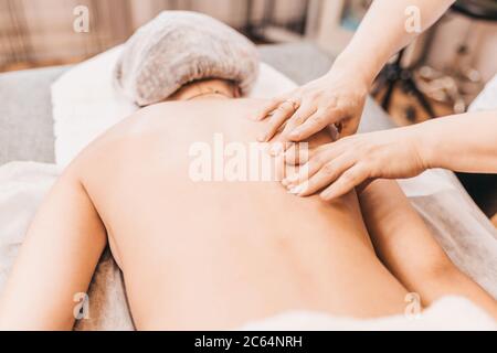 Trattamento del dolore e dello spasmo muscolare alle spalle - traumatologia sportiva - massaggio medico Foto Stock