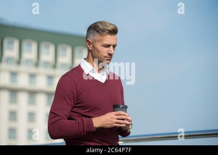 Armonia e equilibrio energetico della vita. Rilassati e ricaricati. Momenti piacevoli. Tranquillità. Pausa caffè. Bere caffè in movimento. Bel ragazzo tenere caffè tazza cielo sfondo spazio copia. Cura di sé. Foto Stock