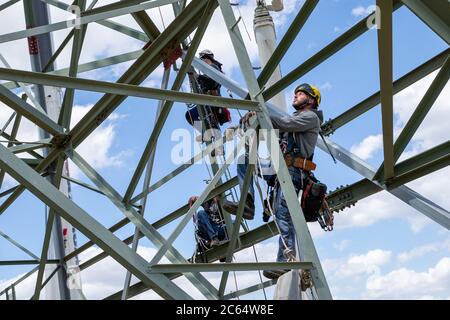 Heidenau, Germania. 06 luglio 2020. Il tecnico Roman Beu (a destra) sale il traliccio di potenza sul suo posto di lavoro. A Heidenau, vicino a Dresda, in Sassonia, è in corso la costruzione di una nuova linea elettrica con tralicci elettrici più potenti per il trasporto di energia elettrica tra la Germania settentrionale e quella meridionale. Registrato in una riunione stampa con l'operatore di rete 50 Hertz. Credit: Daniel Schäfer/dpa-Zentralbild/ZB/dpa/Alamy Live News Foto Stock