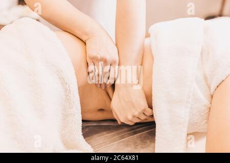 Mani di un massaggiatore professionista al lavoro - un effetto profondo e duro sui muscoli e sui tessuti di una persona Foto Stock