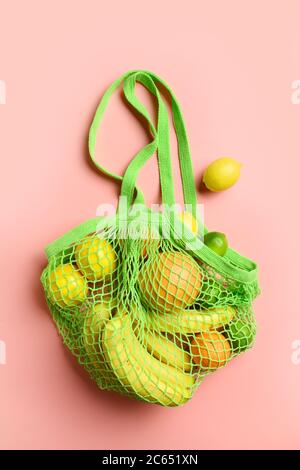 Sacchetto a rete con frutta, limone, arancia. Stile di vita sostenibile e borsa riutilizzabile. Zero sprechi. Verticale. Foto Stock