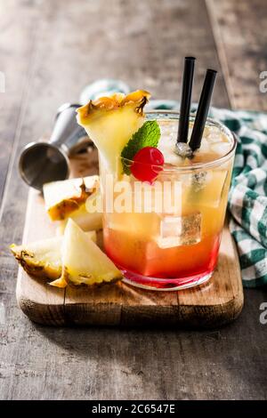 Cocktail mai tai freddo con ananas e ciliegia su tavolo di legno Foto Stock