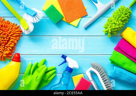 Articoli per la pulizia colorati su tavole di legno blu Foto Stock