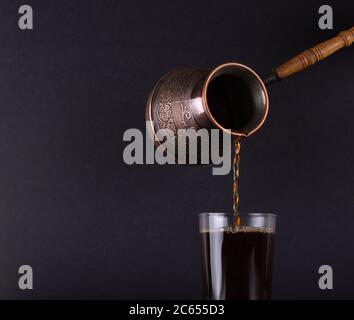 Caffè turco appena preparato versato da Cezve. Foto Stock