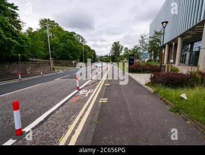 Edimburgo, Scozia, Regno Unito, 7 luglio 2020. Nuove piste ciclabili presso l'ospedale Western General: Il consiglio comunale di Edimburgo ha creato nuove piste ciclabili protette da barriere stradali sulle strade di accesso agli ospedali della città. La politica è quella di incoraggiare sia la sicurezza stradale per i ciclisti, sia le misure di allontanamento sociale a seguito della pandemia per incoraggiare le persone a fare il giro in bicicletta. Le maschere facciali scartate possono essere viste intorno all'ospedale causando un problema di lettiera Foto Stock