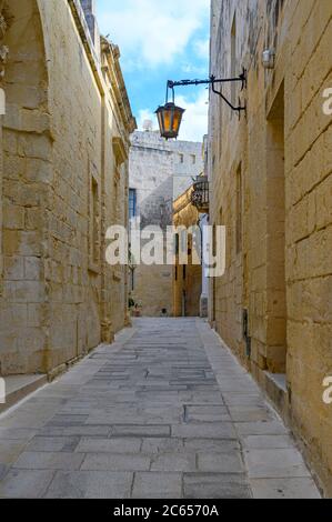 Vista su una delle tante antiche stradine medievali della città di Mdina, Malta Foto Stock