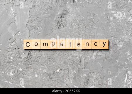 Competency parola scritta sul blocco di legno. La competenza del testo in tabella, concetto. Foto Stock
