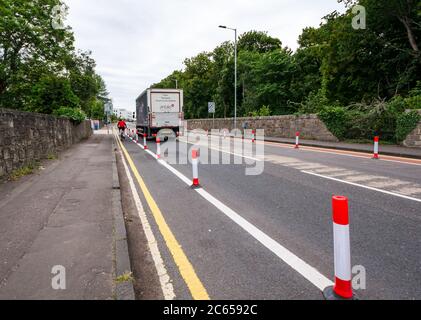 Edimburgo, Scozia, Regno Unito, 7 luglio 2020. Nuove piste ciclabili presso l'ospedale Western General: Il consiglio comunale di Edimburgo ha creato nuove piste ciclabili protette da barriere stradali sulle strade di accesso agli ospedali della città. La politica è quella di incoraggiare sia la sicurezza stradale per i ciclisti, sia le misure di allontanamento sociale a seguito della pandemia per incoraggiare le persone a fare il giro in bicicletta Foto Stock