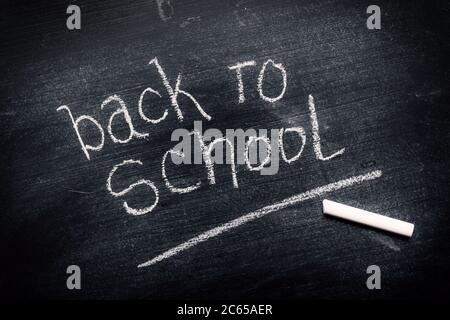 Torna a scuola scritto in gesso su lavagna sporca come sfondo grunge Foto Stock