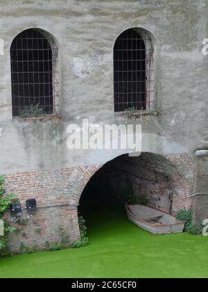 Vista su un bellissimo dettaglio del Castello di San Giorgio a Mantova. Il particolare delle due finestre e del foro di ingresso con una barca legata appare come una fa Foto Stock