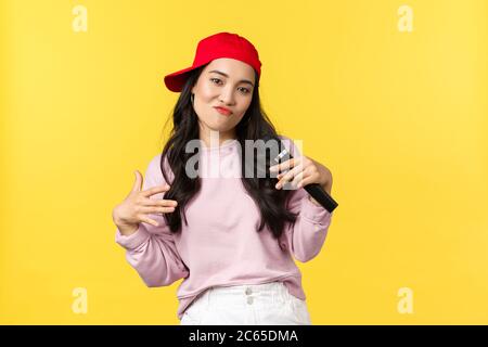 Emozioni della gente, stile di vita e concetto di bellezza. Giovane ragazza elegante e cool rapper in berretto rosso, canto e gesturing, con cui si esibisce Foto Stock