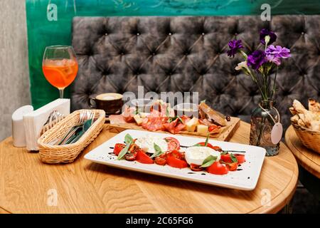 Insalata caprese e un set di antipasti sul tavolo del ristorante, tonato Foto Stock