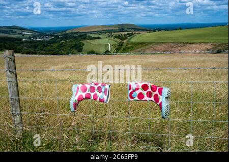Brighton UK 7 luglio 2020 - stivali Wellington lasciato su una recinzione in una giornata di sole sul South Downs appena a nord di Brighton oggi come la previsione è per il tempo non regolato in tutta la Gran Bretagna nei prossimi giorni: Credit Simon Dack / Alamy Live News Foto Stock