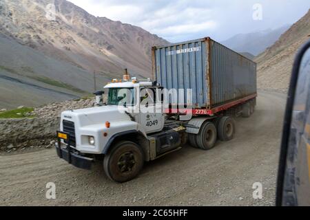 Carrelli container che guidano sulla strada sterrata ben mantenuta per la miniera d'oro Kumtor.Kirghizistan Foto Stock