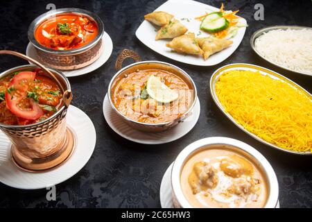 Tavolo con piatti tipici indiani, curry di pollo, tandoori, masala di tikka, korma, riso pilaf. Foto Stock