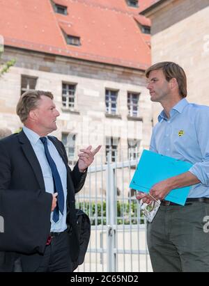 Norimberga, Germania. 07 luglio 2020. Hubertus Freiherr von Frailsheim (r) parla con il suo avvocato Ralf Bornhorst di fronte alla costruzione del Tribunale Regionale di Norimberga-Fürth. Cailsheim sta citando lo Stato libero di Baviera per i danni perché gli agenti di polizia - a suo parere prematuramente - hanno sparato la sua mucca fuori controllo nel maggio 2019. La polizia aveva percepito 'rabbia in ritardo' - ma secondo l'allevatore di bestiame, l'animale era solo spaventata. La corte ha proposto una soluzione. Credit: Daniel Karmann/dpa/Alamy Live News Foto Stock