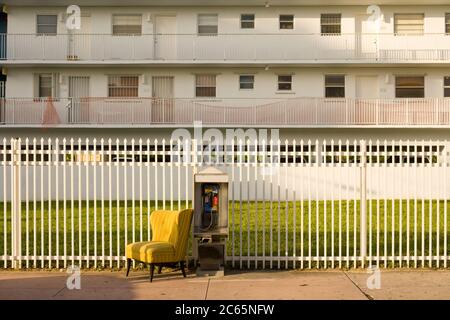 South Beach, Miami Beach, Miami, Florida, Stati Uniti - Telefono a pagamento e divano davanti ad un edificio di appartamenti. Foto Stock