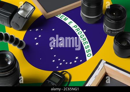 Bandiera nazionale del Brasile con vista dall'alto di attrezzature e strumenti personali per fotografi su tavolo di legno bianco, spazio per la copia. Foto Stock