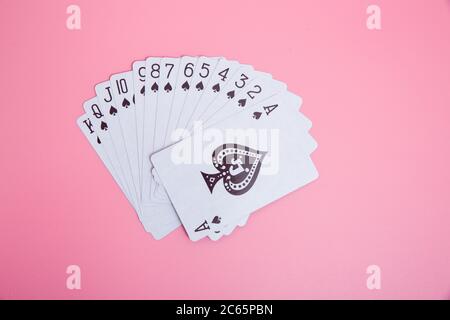 Carte da gioco espanse su sfondo rosa Foto Stock