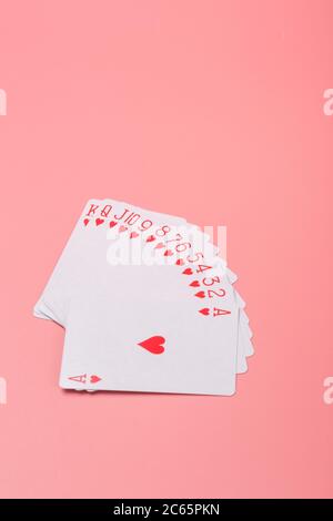 Carte da gioco espanse su sfondo rosa Foto Stock