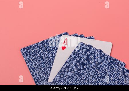 Carte da gioco espanse su sfondo rosa Foto Stock