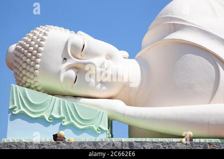 Enorme dormendo o distendendo giù la statua del Buddha nel complesso della Pagoda di Vinh Trang vicino alla città di My Tho, Vietnam Foto Stock