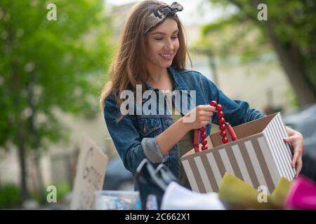 Positivo donna felice che acquista una bella collana rossa Foto Stock