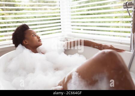 Donna rilassante in una vasca da bagno Foto Stock