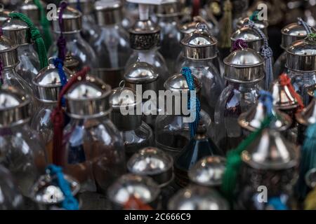 Bottiglie di vetro con tappo argento in un negozio di spazzatura souk per vecchie macchine fotografiche e cartelli a Marrakech, Marocco Foto Stock