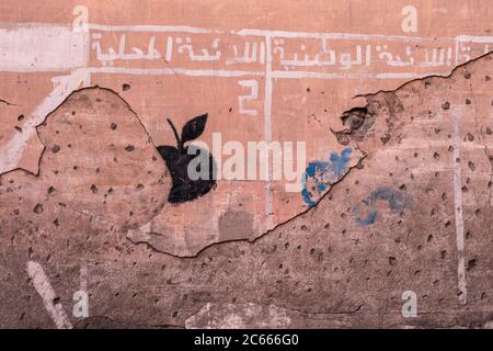 Graffiti da parete con mela su una parete rosso-marrone a Marrakech, Marocco Foto Stock
