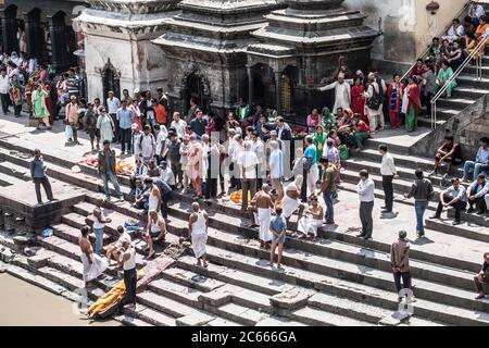 Lavaggio rituale di cadaveri sulle scale del tempio di Pashupatinath a Kathmandu, Nepal Foto Stock