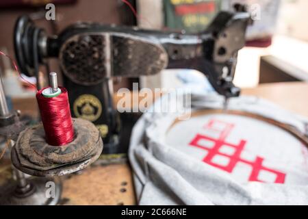 Bobina per filo con macchina da cucire in un negozio di t-shirt a Kathmandu, Nepal Foto Stock