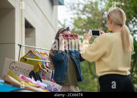 Bella giovane donna che scatta foto del suo amico Foto Stock