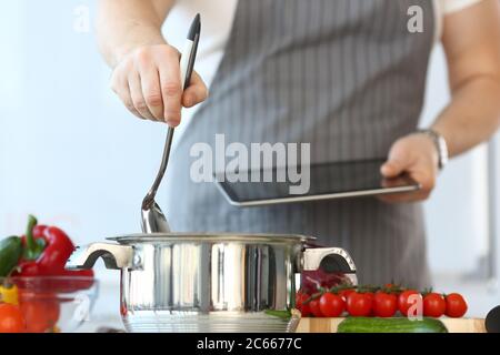 Foto ritagliata di uomo in piedi in cucina e in cucina Foto Stock