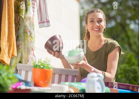 Gioiosa attraente donna che acquista vasi di fiori in vendita Foto Stock